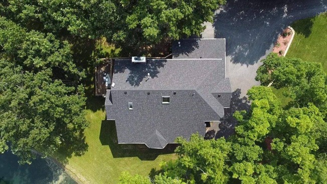 residential house roof with new black shingles